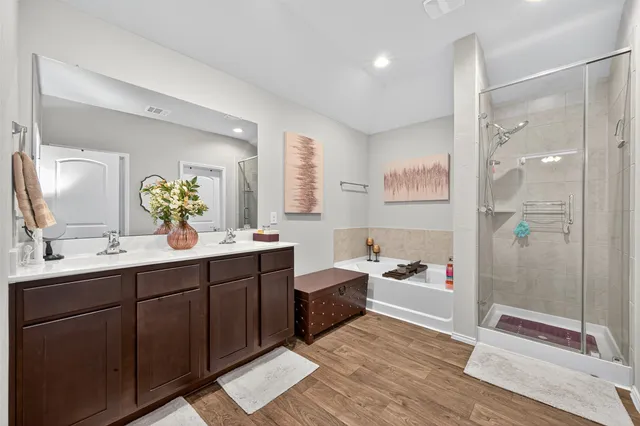 a spacious bathroom with a tub sink shower and mirror