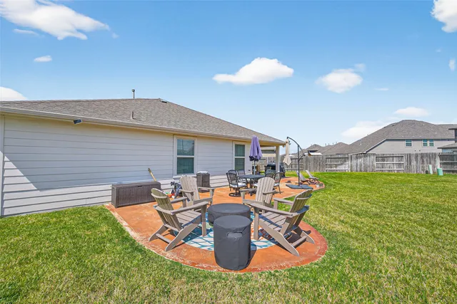 a view of a backyard with table and chairs potted plants and a palm tree