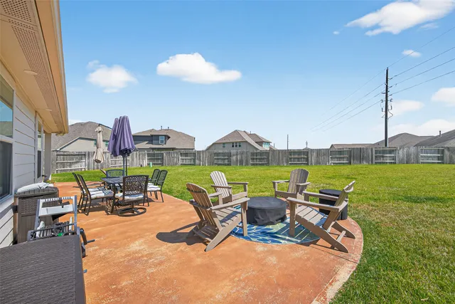 a view of a patio with table and chairs floor to ceiling window and yard