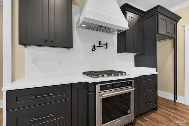 a kitchen with wooden cabinets and a stove top oven