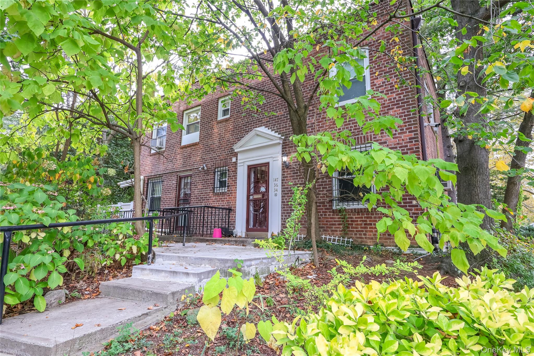 a front view of a house with a large tree