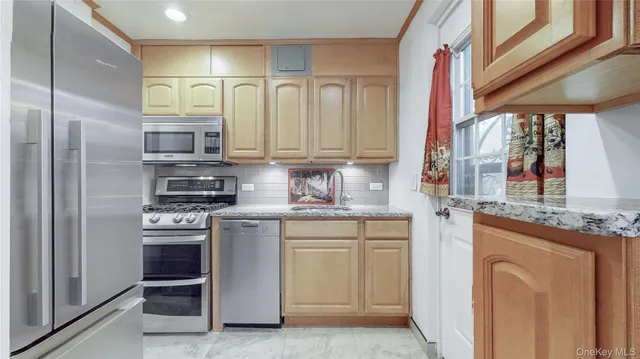 a kitchen with stainless steel appliances granite countertop a stove a sink and a refrigerator