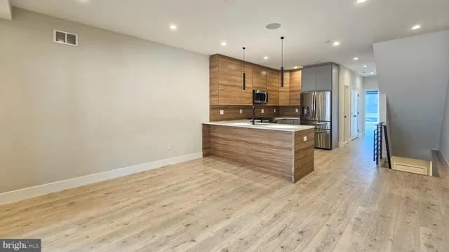 a kitchen with stainless steel appliances kitchen island granite countertop a stove a refrigerator and a oven