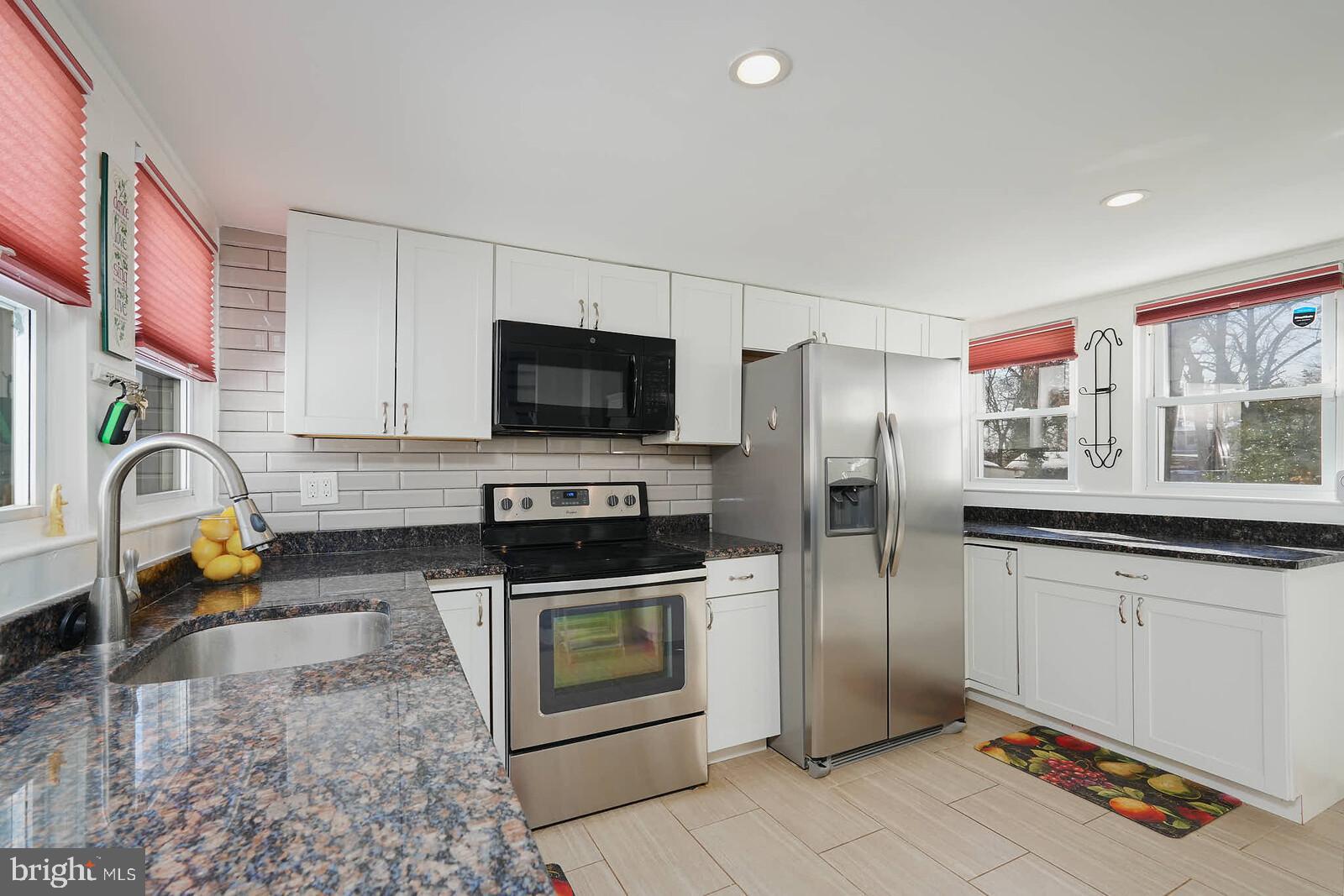 7719 Garrison Road Hyattsville, MD 20784 - Photo 5 of 23 a kitchen with stainless steel appliances granite countertop a refrigerator and a stove top oven