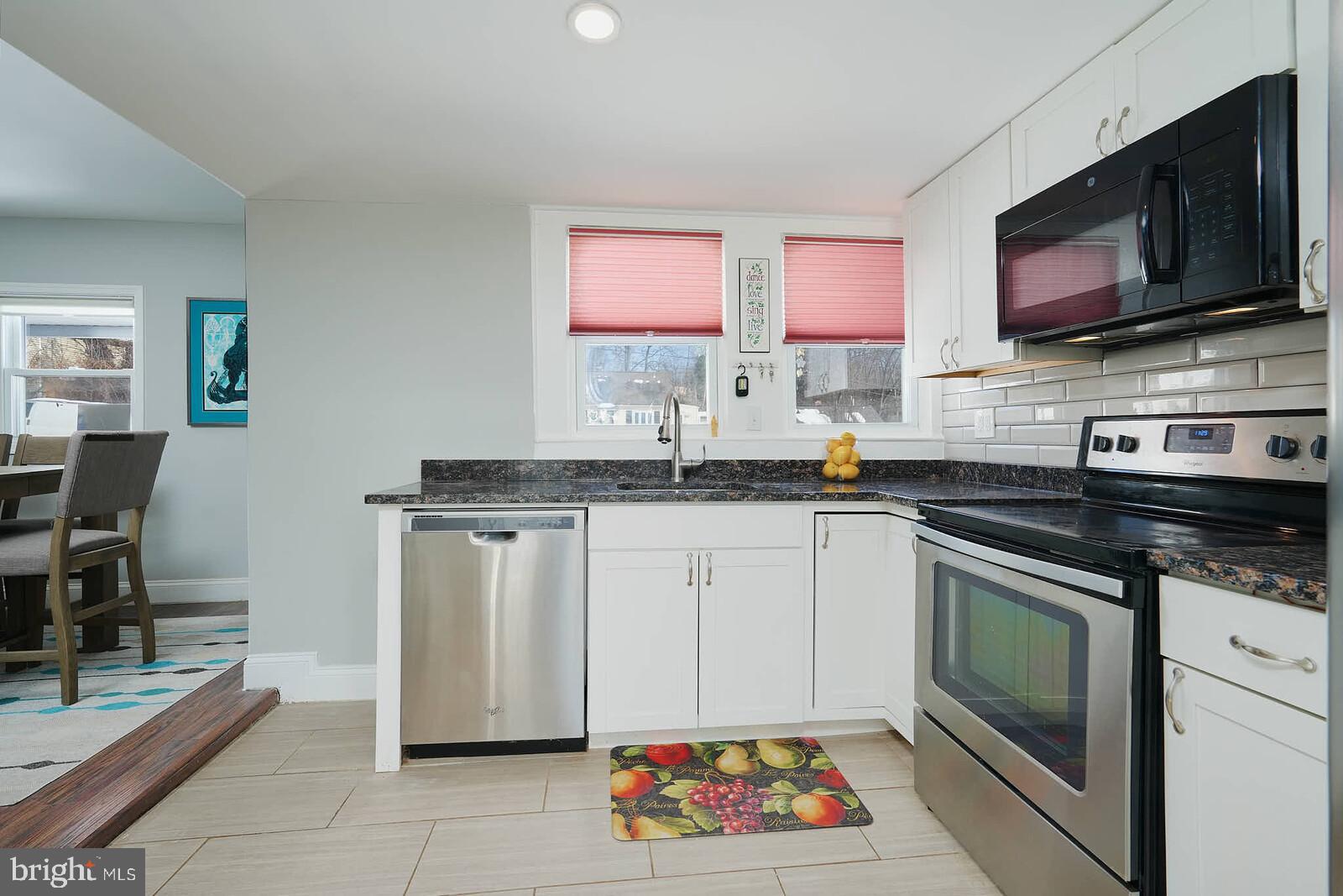 7719 Garrison Road Hyattsville, MD 20784 - Photo 6 of 23 a kitchen with stainless steel appliances a stove microwave and sink
