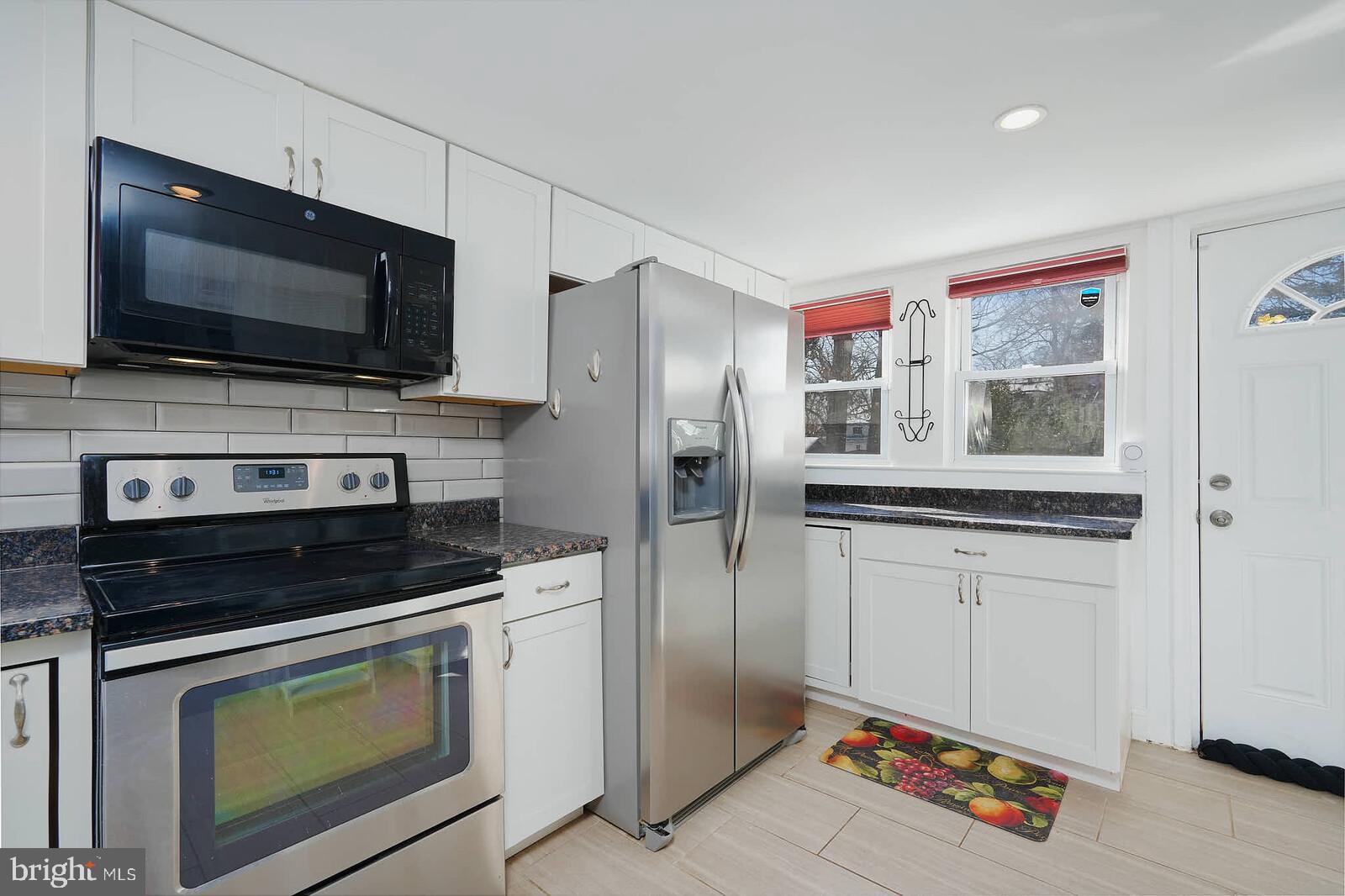 7719 Garrison Road Hyattsville, MD 20784 - Photo 7 of 23 a kitchen with stainless steel appliances a stove microwave and refrigerator