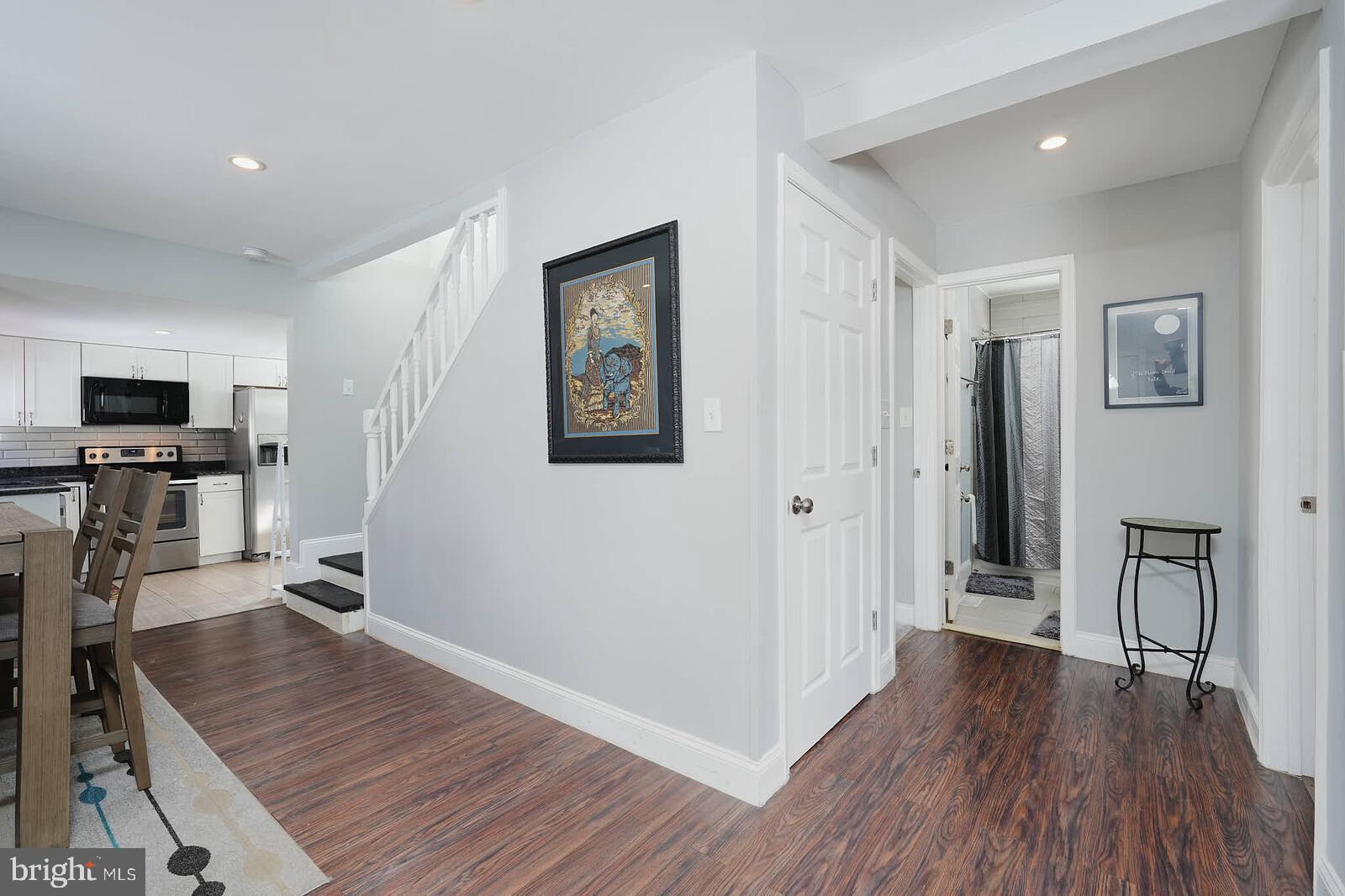 7719 Garrison Road Hyattsville, MD 20784 - Photo 9 of 23 a view of a hallway with wooden floor and a flat screen tv