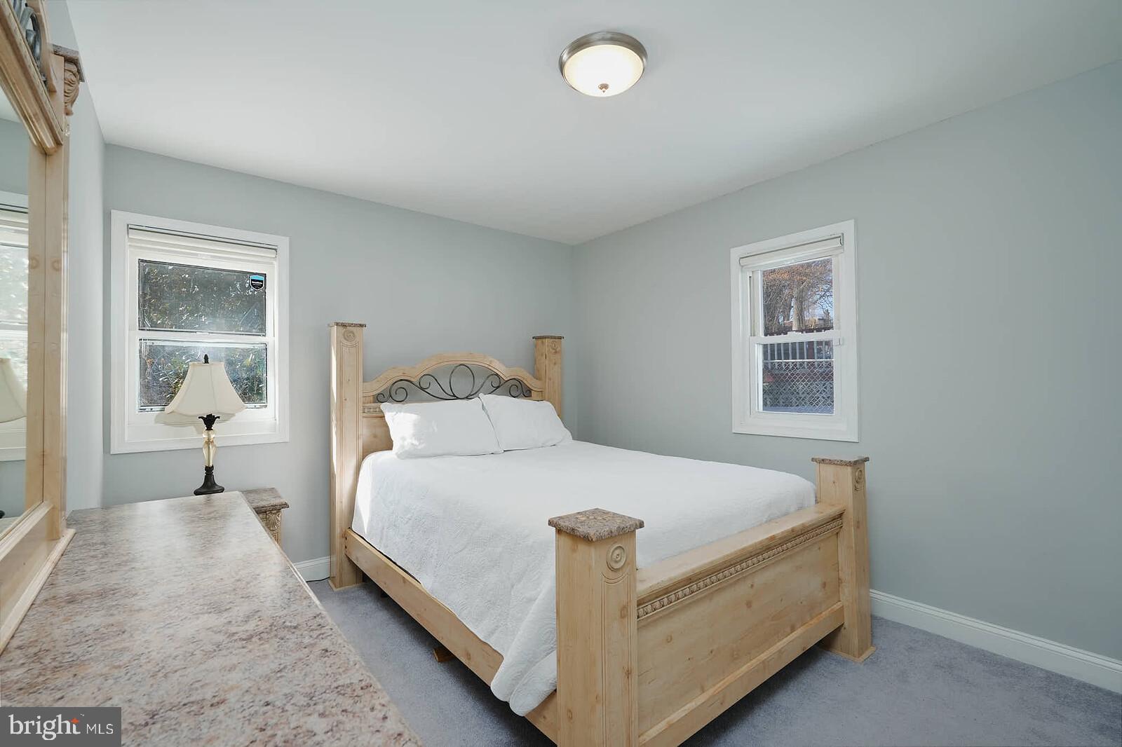 7719 Garrison Road Hyattsville, MD 20784 - Photo 10 of 23 a large bed sitting in a bedroom next to a window and a lamp