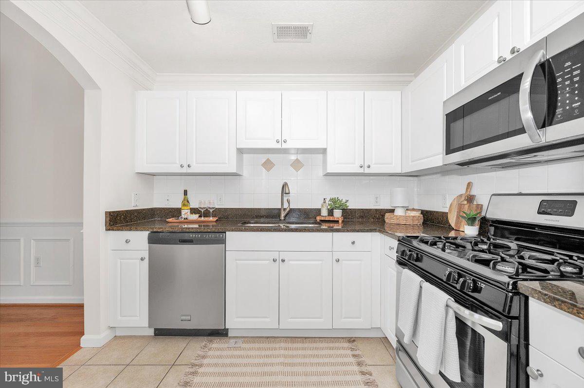 7 Booth Street, Unit 406 Gaithersburg, MD 20878 - Photo 23 of 117 a kitchen with stainless steel appliances granite countertop a sink stove and microwave