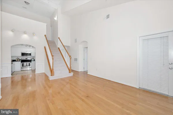 a view of a hallway with wooden floor and staircase