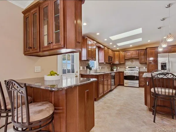 a kitchen with stainless steel appliances kitchen island granite countertop a sink and cabinets