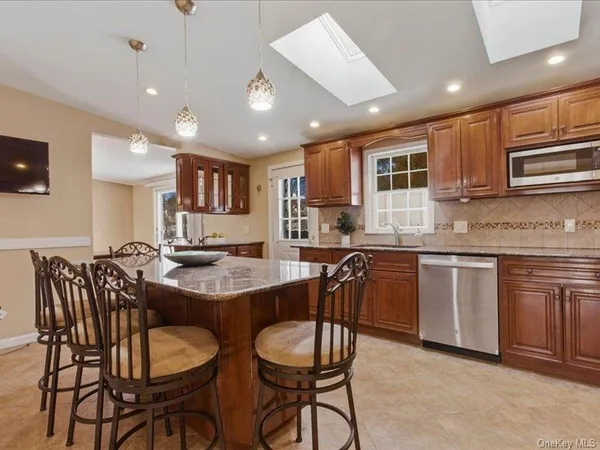 a kitchen with a dining table chairs stainless steel appliances and cabinets