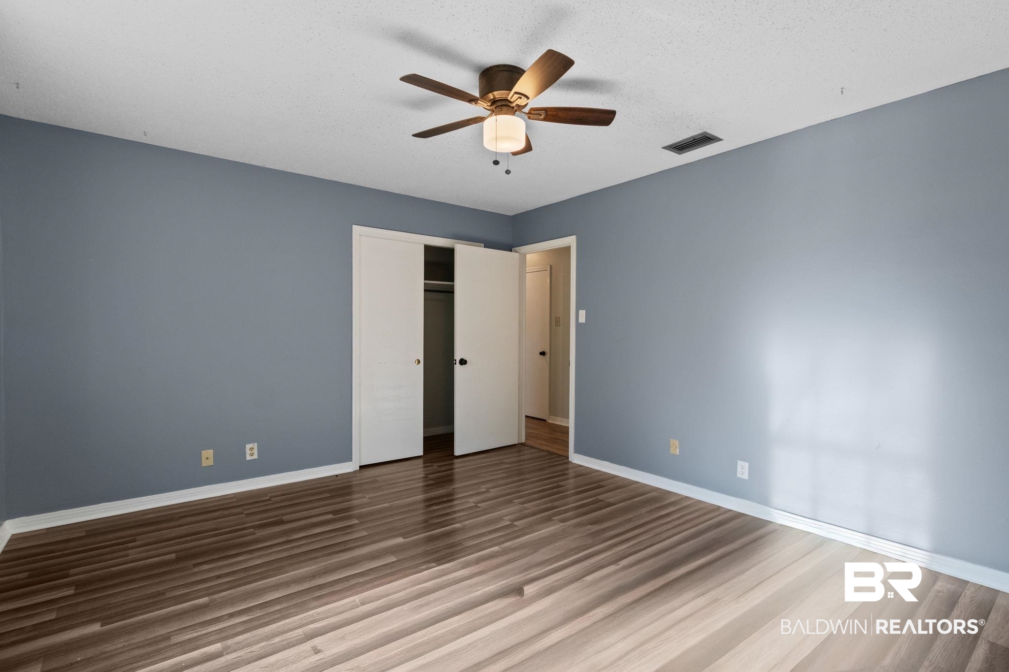 3864 Leroy Stevens Road Mobile, AL 36619 - Photo 21 of 33 Unfurnished bedroom with a ceiling fan, a closet, and dark wood-type flooring