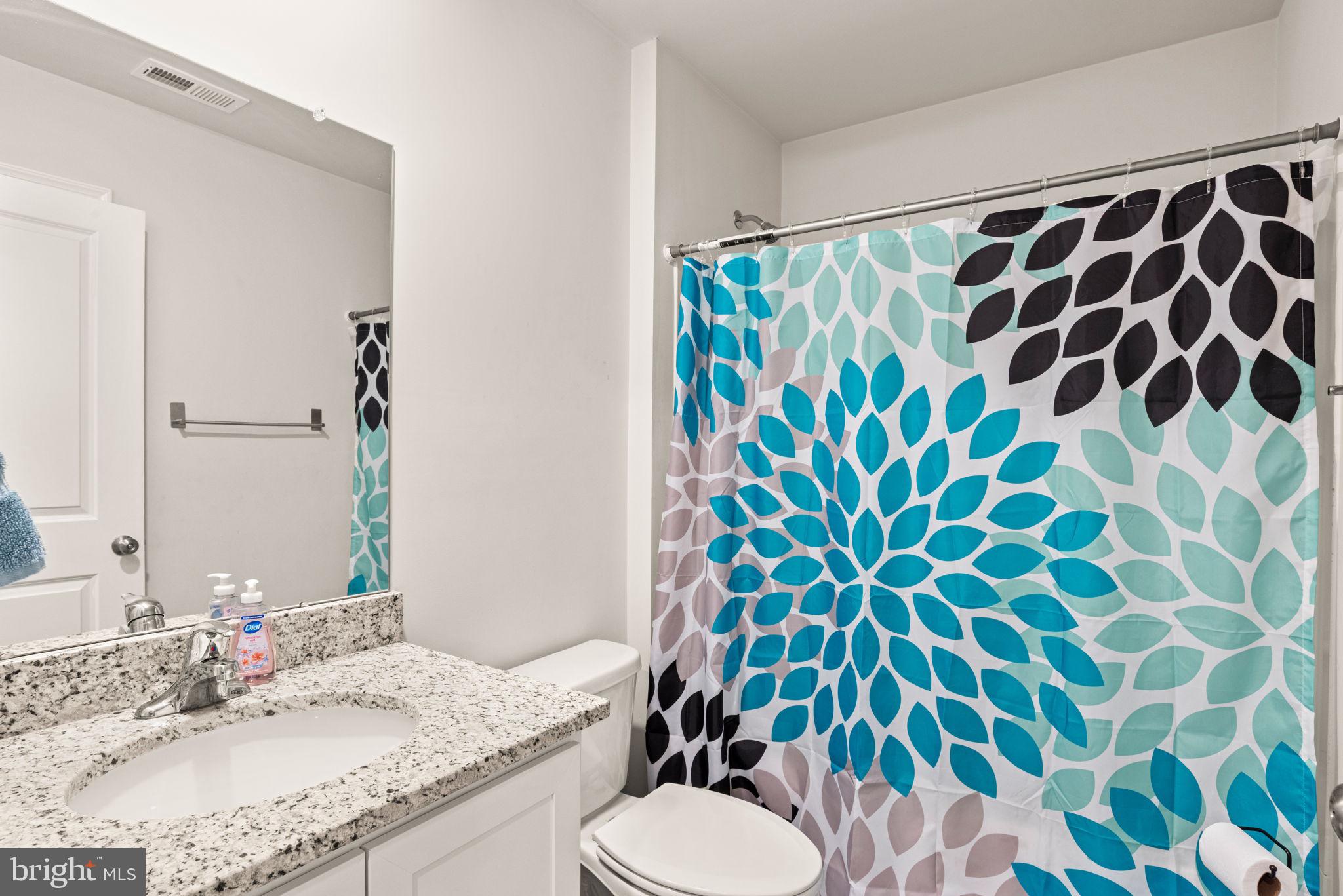 310 Maple Run Drive York, PA 17404 - Photo 22 of 28 a bathroom with a granite countertop sink a toilet and a shower curtain