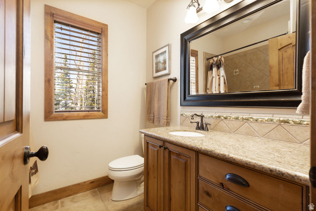382 Ridgeview Street, Unit 8 & 9 Brian Head, UT 84719 - Photo 44 of 52 Bathroom featuring a wood-framed window, natural wood vanity with stone countertop, drop-in sink, and a large framed mirror