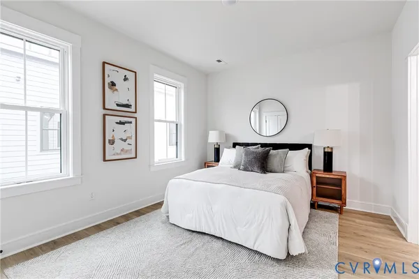 a bedroom with a bed mirror and window