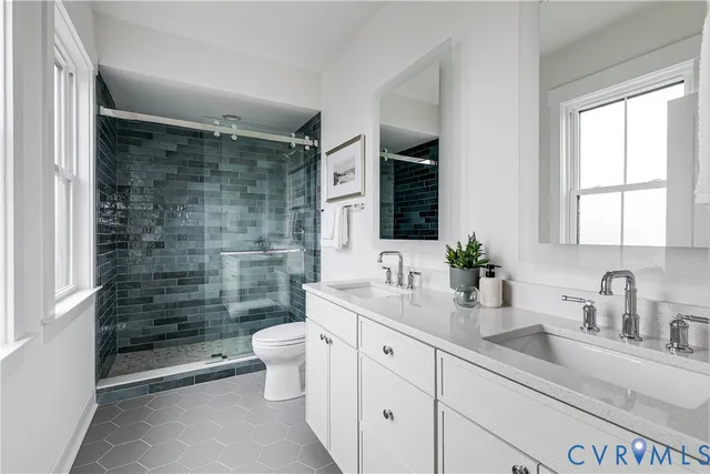 a bathroom with a double vanity sink toilet and shower