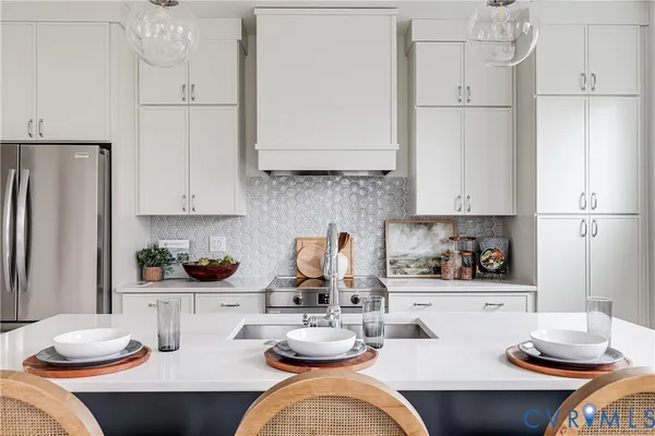 a kitchen with stainless steel appliances kitchen island granite countertop a sink refrigerator and cabinets