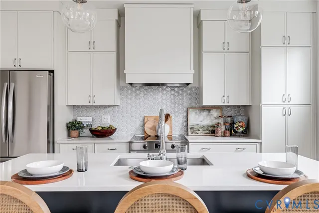 a kitchen with stainless steel appliances kitchen island granite countertop a sink refrigerator and cabinets