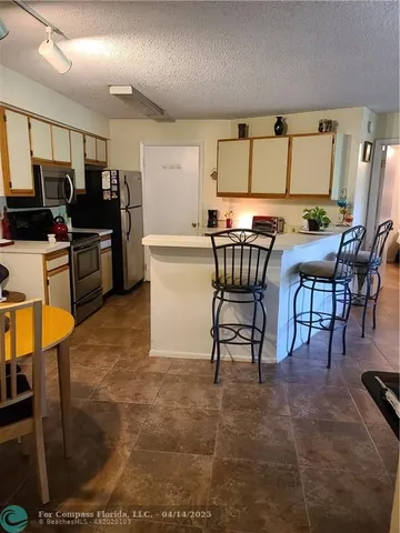 a kitchen with a sink a stove and white cabinets