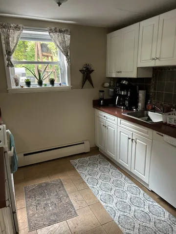 a kitchen with a sink window and cabinets