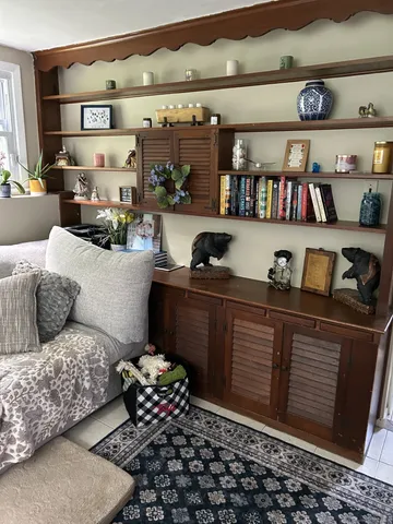 a living room with furniture and a book shelf