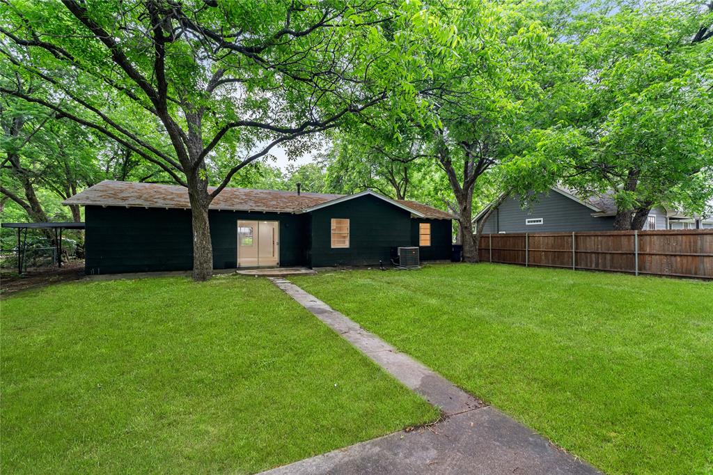 110 Hackberry Street Lancaster, TX 75146 - Photo 25 of 32 Expansive grassy lawn with a concrete pathway leading to the home's rear entrance