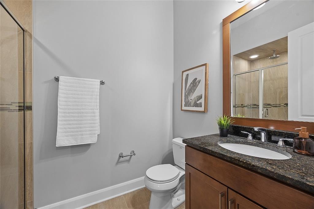 301 Fifth Avenue, Unit 506 Pittsburgh, PA 15222 - Photo 14 of 21 a bathroom with a granite countertop sink toilet and a mirror