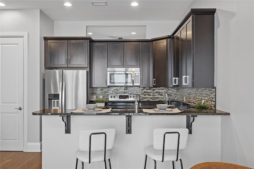 301 Fifth Avenue, Unit 506 Pittsburgh, PA 15222 - Photo 5 of 21 a kitchen with stainless steel appliances granite countertop a refrigerator a sink a stove and island