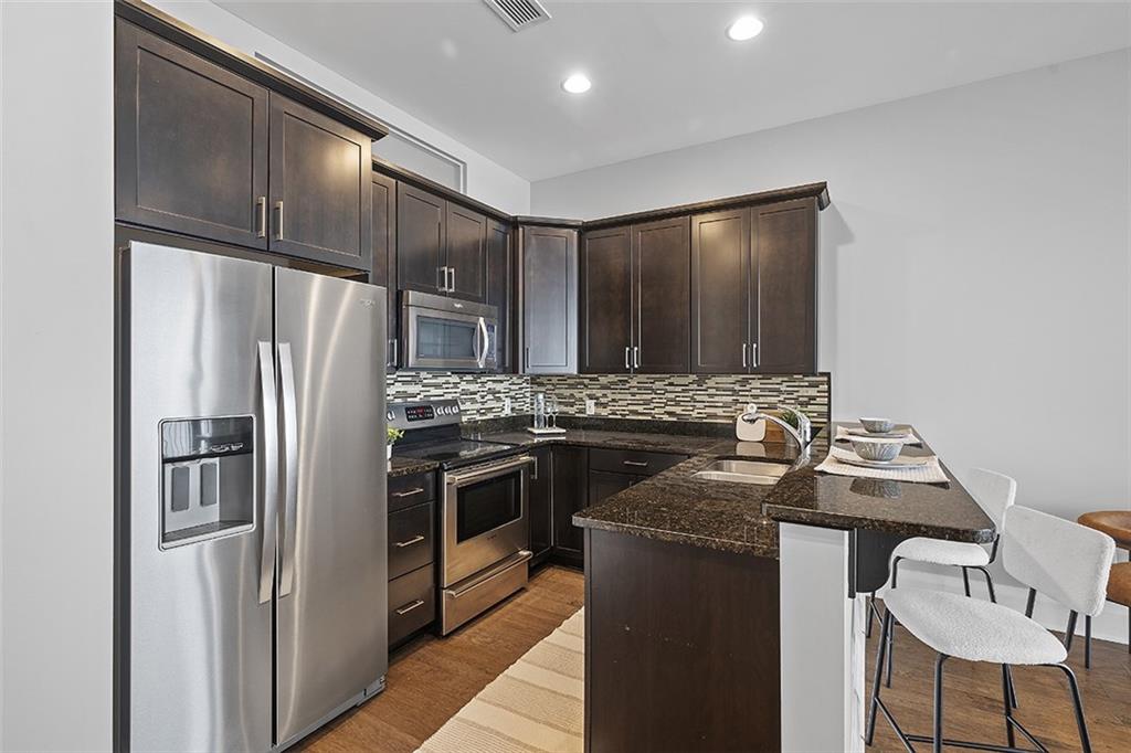 301 Fifth Avenue, Unit 506 Pittsburgh, PA 15222 - Photo 6 of 21 a kitchen with stainless steel appliances granite countertop a stove and a refrigerator