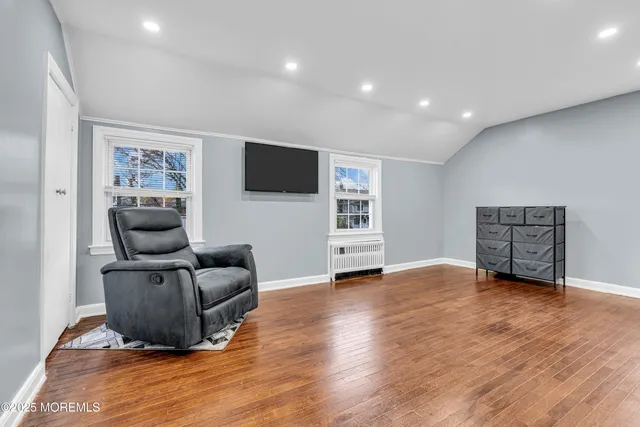 a view of empty room with wooden floor and window