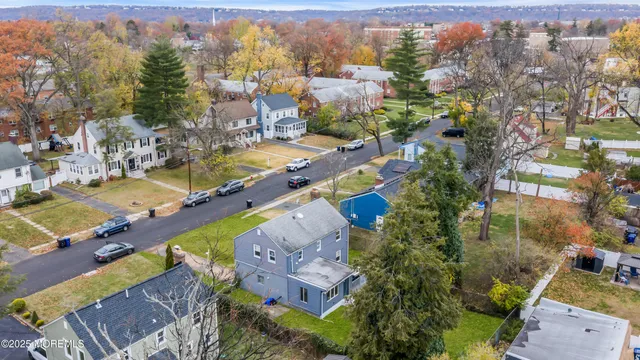 an aerial view of residential house with yard and mountain view in back