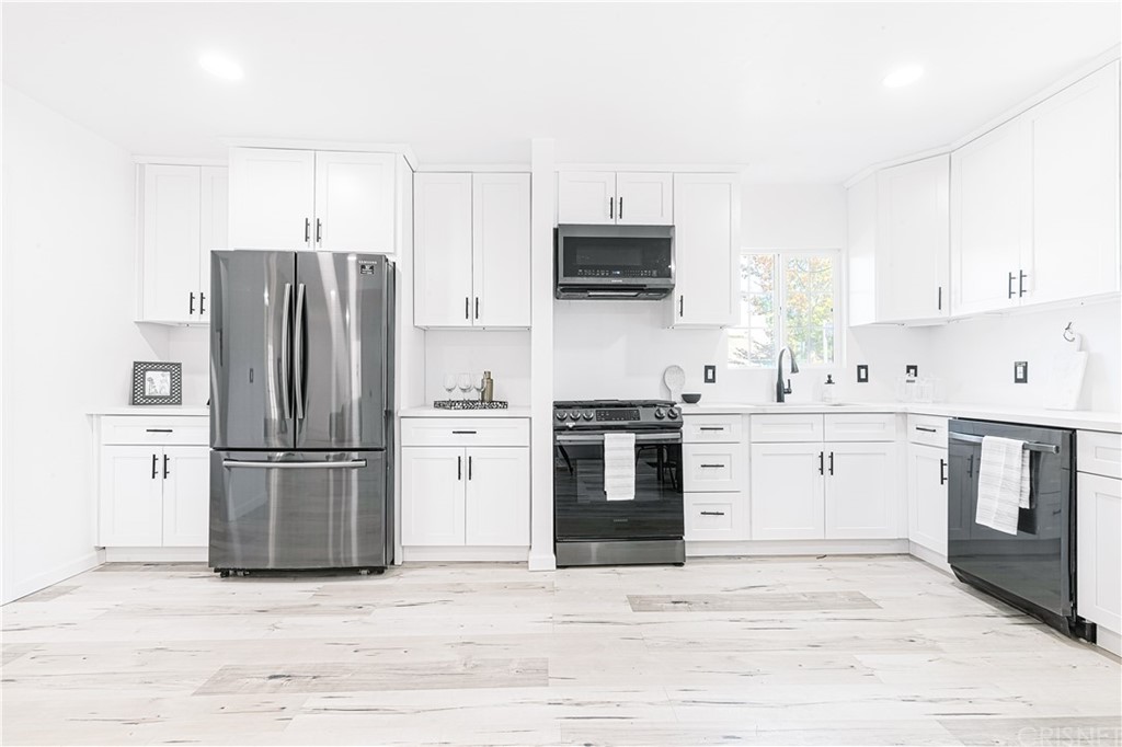 6725 Belmar Avenue Reseda, CA 91335 - Photo 11 of 32 a kitchen with stainless steel appliances a refrigerator stove and white cabinets