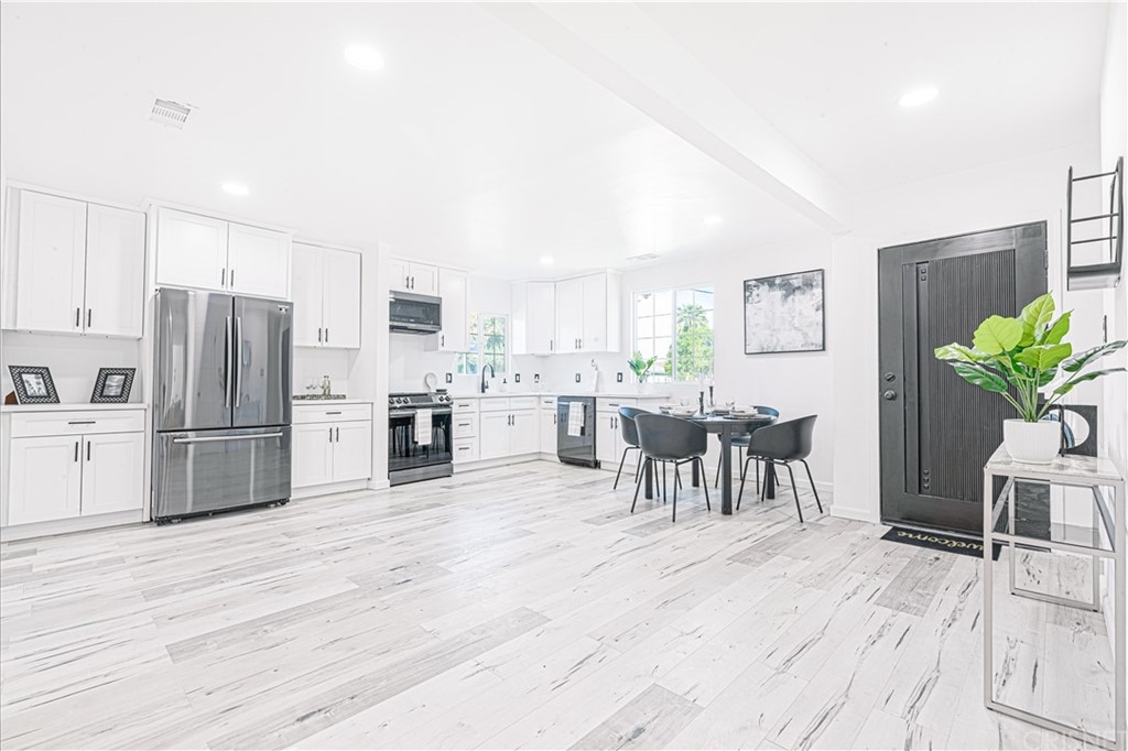 6725 Belmar Avenue Reseda, CA 91335 - Photo 12 of 32 a kitchen with stainless steel appliances a refrigerator a stove a dining table and chairs