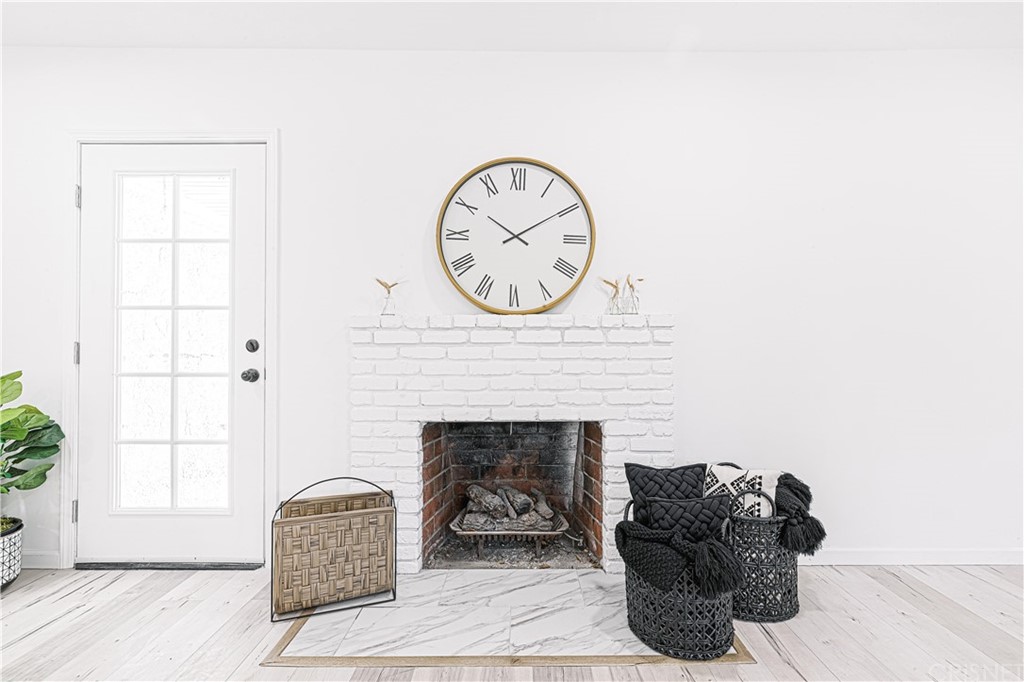 6725 Belmar Avenue Reseda, CA 91335 - Photo 18 of 32 a living room with furniture a clock and a fireplace
