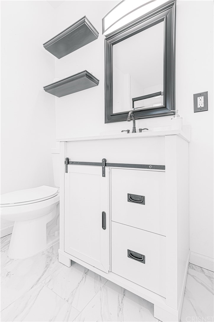 6725 Belmar Avenue Reseda, CA 91335 - Photo 22 of 32 a bathroom with a toilet sink and mirror