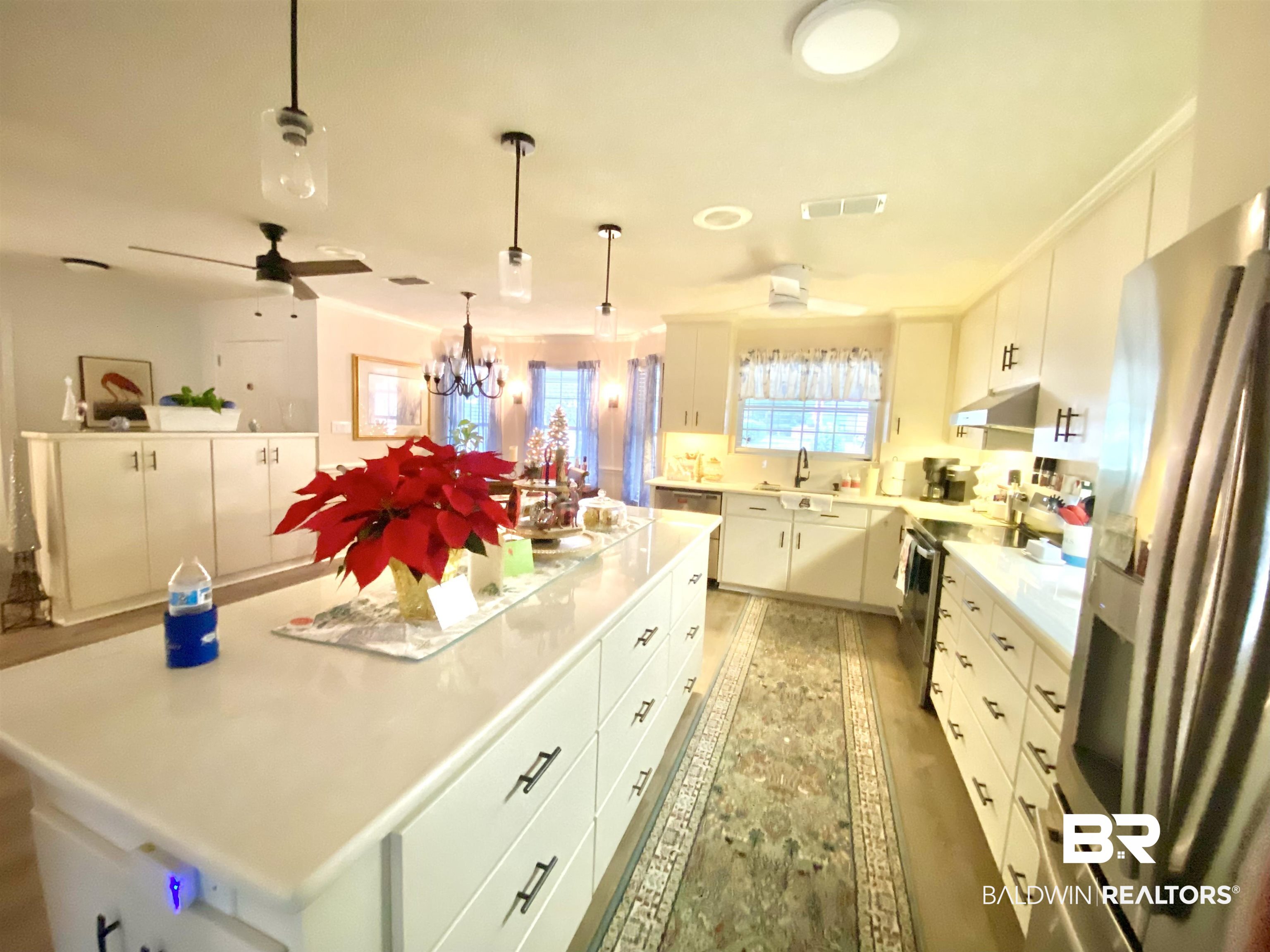 2872 Avenida Alberto Lillian, AL 36549 - Photo 13 of 31 Kitchen featuring white cabinets, decorative light fixtures, a center island, and stainless steel appliances