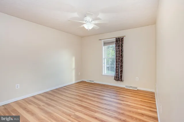 a view of a room with wooden floor and fan