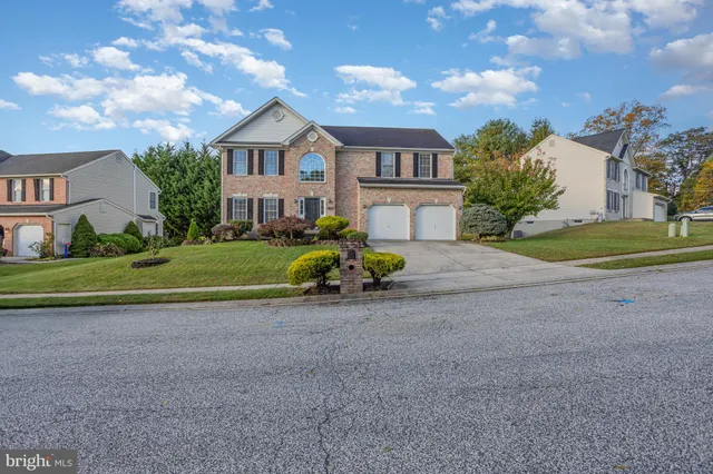 a view of a house with a big yard and large trees
