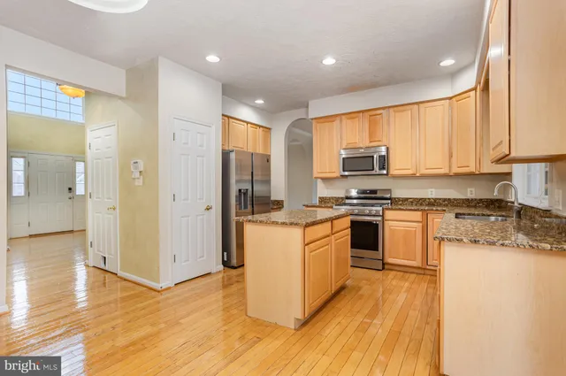 a kitchen with granite countertop a stove top oven a sink and a refrigerator