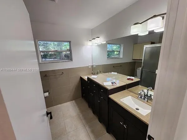 a bathroom with a sink a stove and a mirror