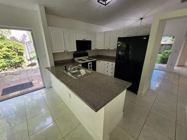 a kitchen with stainless steel appliances a microwave a sink and a refrigerator