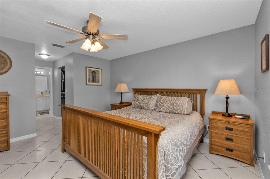 24415 Buckingham Way Punta Gorda, FL 33980 - Photo 13 of 41 a bedroom with a bed and a chandelier
