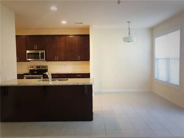 a view of kitchen with stainless steel appliances granite countertop a sink and a stove