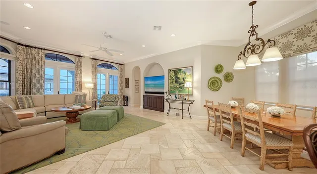 a dining hall with stainless steel appliances kitchen island granite countertop a table and chairs