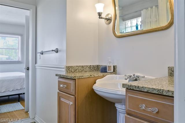 737 Mooring Line Drive Naples, FL 34102 - Photo 13 of 24 a bathroom with a granite countertop sink and a mirror