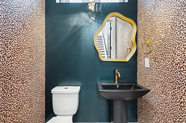 a bathroom with a toilet a sink and mirror