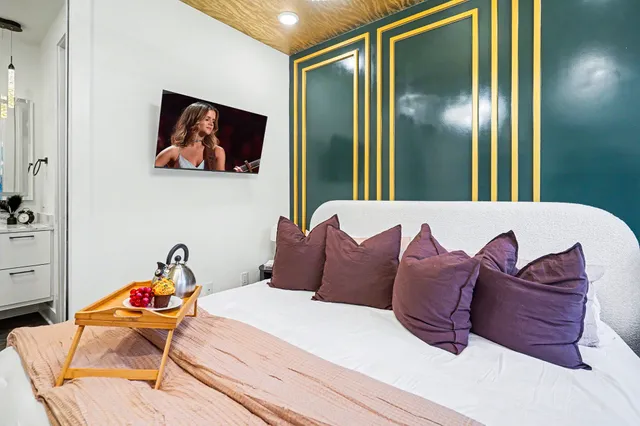 a bedroom with a bed and a painting on the wall