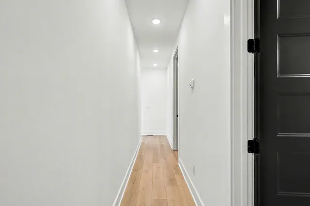 a view of a hallway with wooden floor