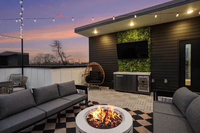 a living room with furniture a floor to ceiling window and potted plants